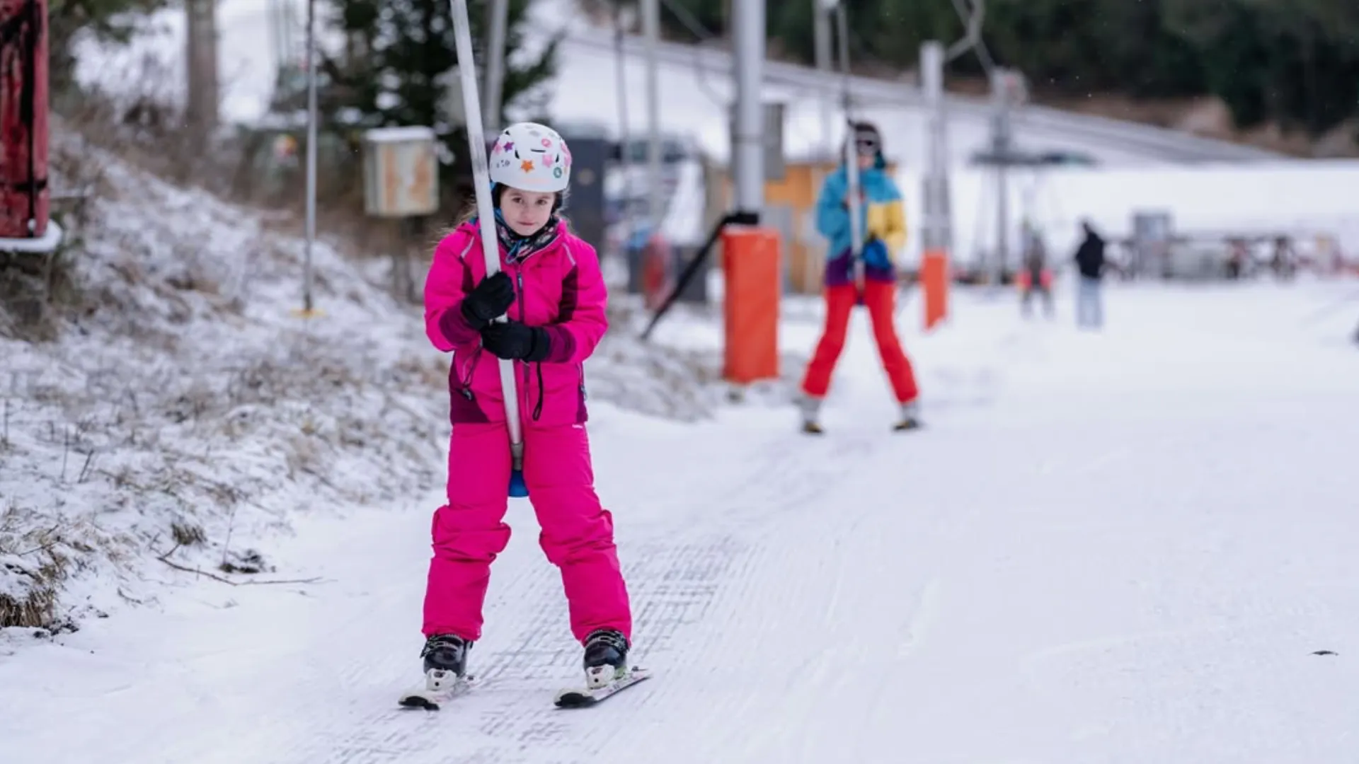 Dievča v ružovej kombinéze na vleku
